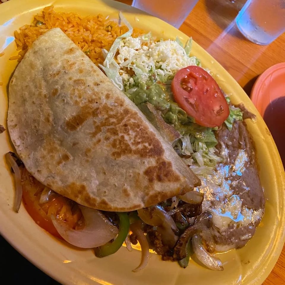 A Casa Grande Cantina & Grill Mexican combo plate with a quesadilla, rice, beans, guacamole, and salad.